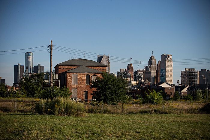 An abandoned home is seen with the Detroit skyline in the background