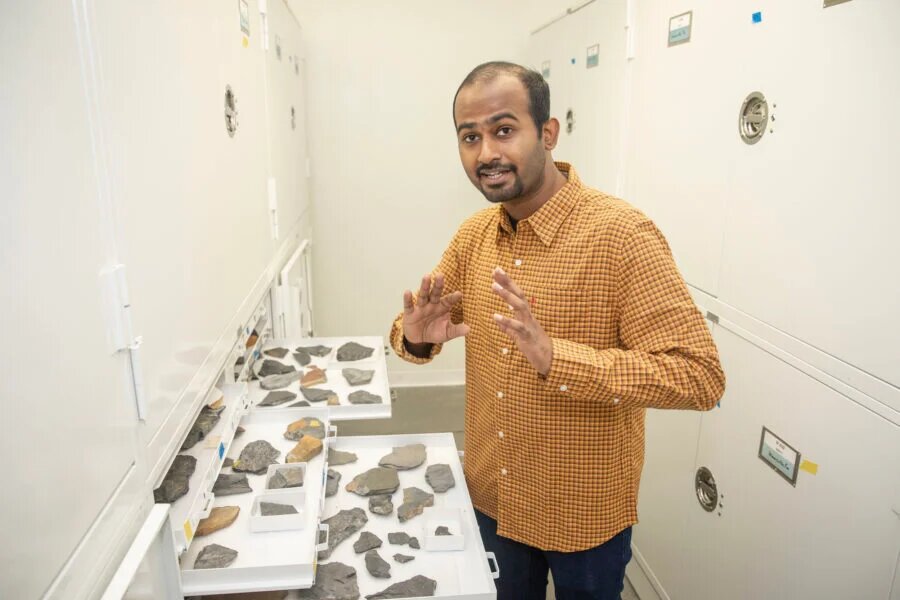 "Seeking clues to how shifting climate may change ocean ecosystems; photo of Anshuman Swain with fossils on display"