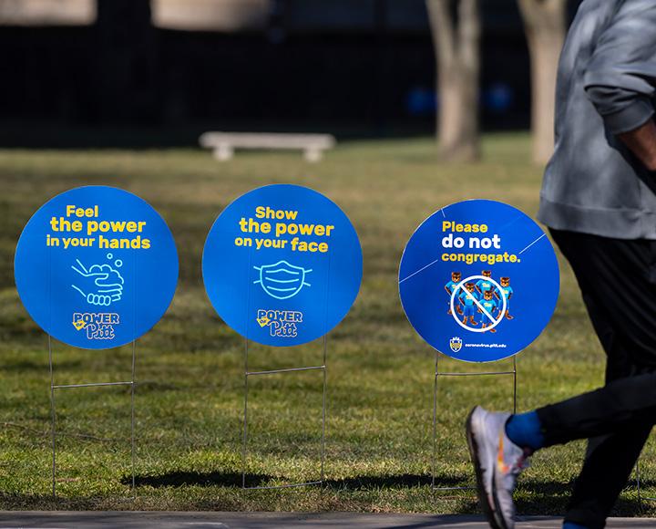 "Pitt’s pandemic practices could serve as an example for other institutions; Picture of students waiting in line"