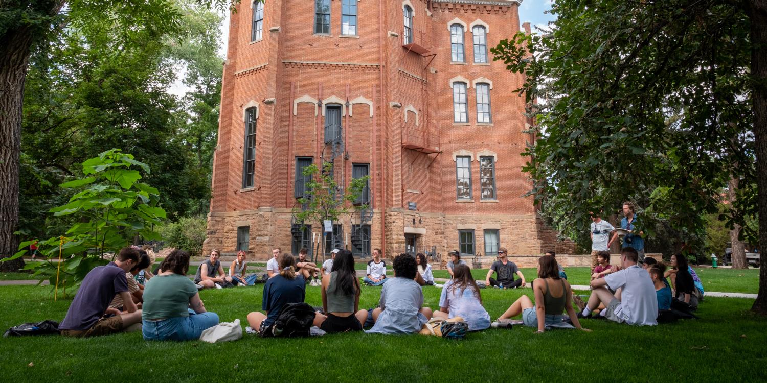 CU Boulder Doubles Size Of CU Promise Free Tuition And Fees Program; Students sitting in lawn front of building