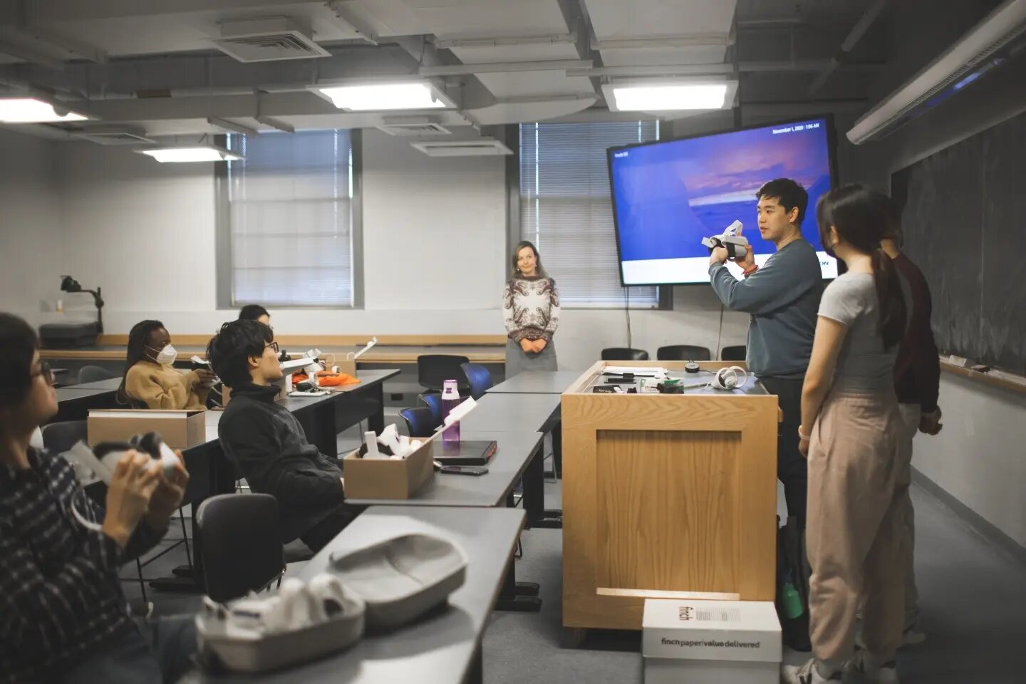 "Chemistry Students Take a Virtual Dive Into Materials; Students in the DALI Lab who helped create the virtual reality app lead a brief tutorial on using the headsets. At center, standing, is chemistry professor Katherine Mirica. (Photo by Katie Lenhart)"