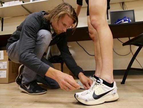 Wouter Hoogkamer places motion sensors on a runner in order to test the biomechanics of the Nike Zoom Vaporfly 4% shoe. (Credit: Casey A. Cass/CU Boulder)