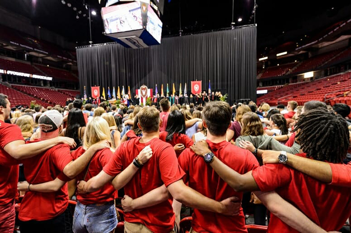 First-year students sing “Varsity” at the end of the Chancellor’s Convocation for New Students at the Kohl Center.