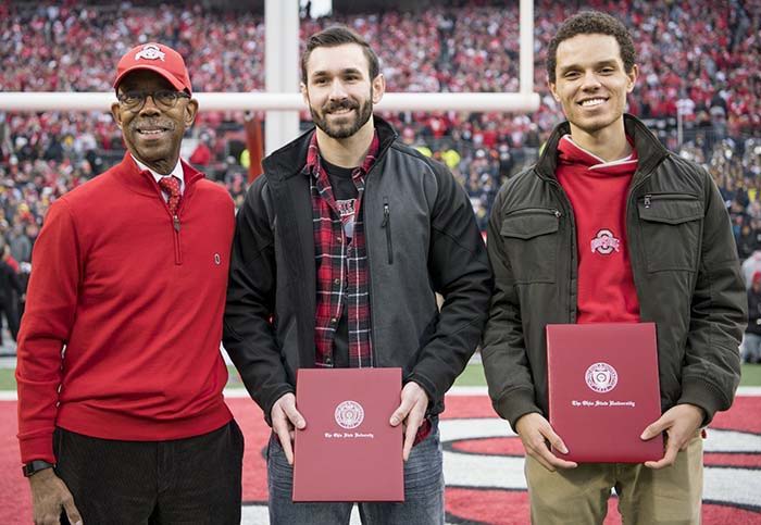 Ohio State President Michael V. Drake stands with Zac Graber and Christian McGhee