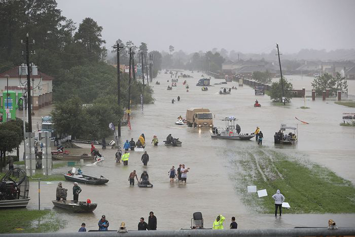 People walk down a flooded street as they evacuate their homes after flooding from Hurricane Harvey on August 28, 2017 in Houston, Texas.