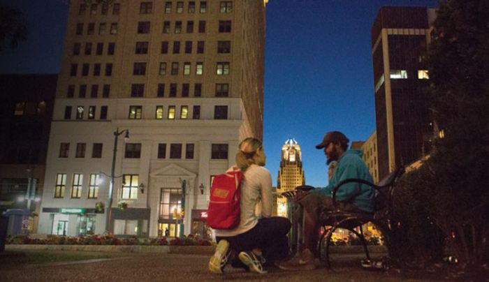 A UB HEALS team member checks on the welfare of a homeless man in downtown Buffalo.