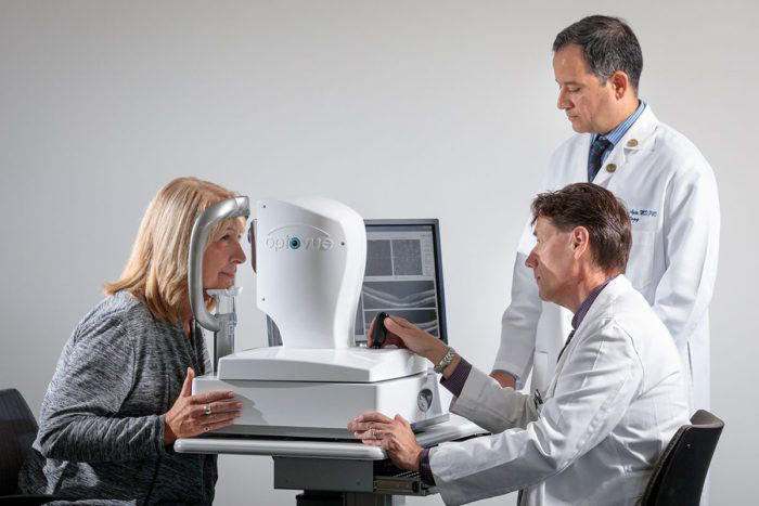 Gregory Van Stavern, MD, (seated) and Rajendra Apte, MD, PhD, examine Kathleen Eisterhold's eyes.