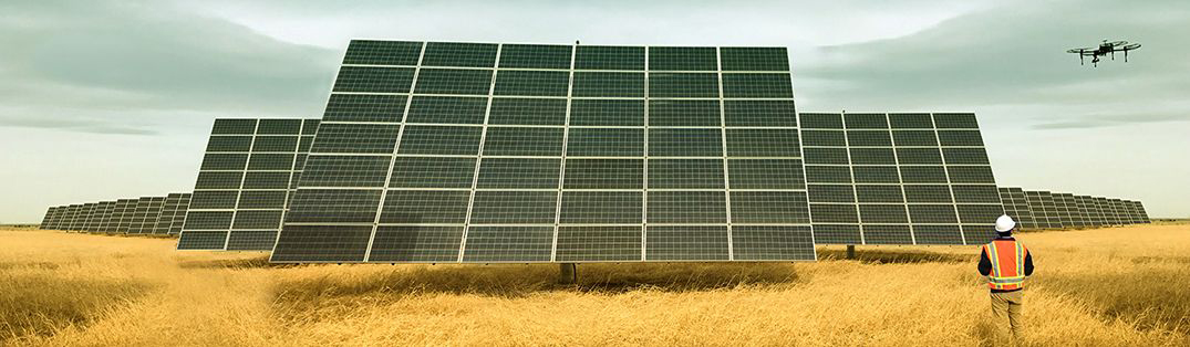 Worker using drone to monitor solar panels