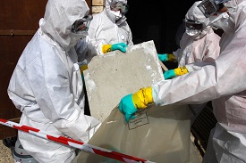 People in Hazmat suits handling asbestos