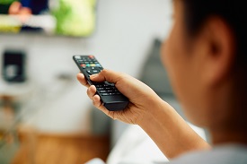 Person using a remote control for a television