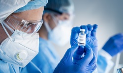 researcher holds vaccine bottle in hands
