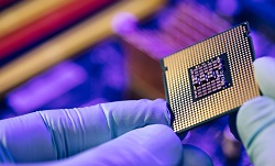 A gloved hand holding a microchip