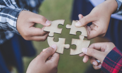 children holding puzzle pieces in a cirlce