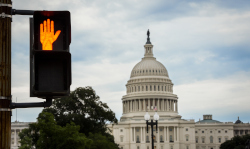 A pedestrian stop sign in front of the Capitol building