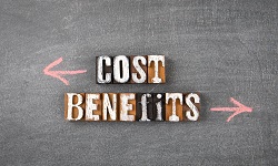 The words cost and benefits on a blackboard with arrows pointing in oppoiste directions