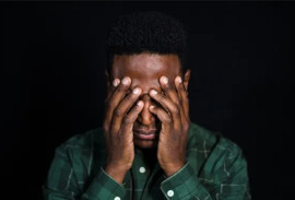 A frustrated man with hs hand over his eyes
