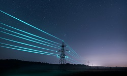 Transmission towers with glowing electric wires against a starry sky