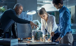 A team of engineers examine circuit boards