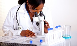 A scientist looks through a microscope