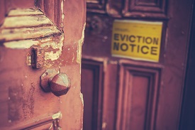 Photo of deteriorated door with an eviction notice