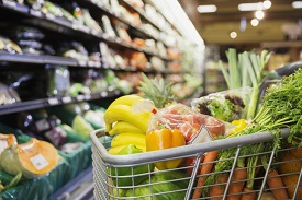 A grocery cart full of vegetables in a grocery store
