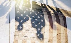 Shadows of people against the backdrop of a U.S. flag