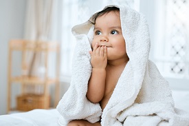 An infant draped in a bath towel