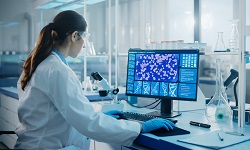 a biomedical scientist working on a computer showing images of gene editing