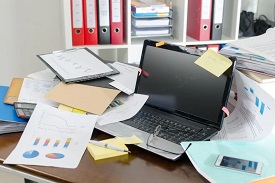 Messy desk with business papers and a laptop