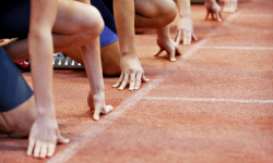 Athletes lining up at the starting line fof a footrace