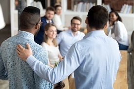 An individual introduces another individual to a group of people
