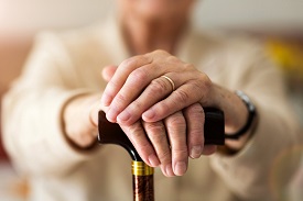 An older person holding a cane