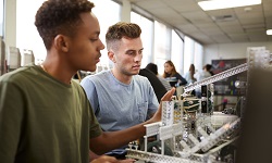 Two university students building machine in science robotics or engineering class