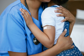 A school nurse hugging a child