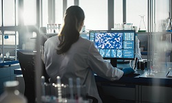Biochemist working on a computer in a lab