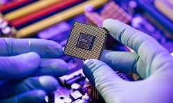 Someone's hands wearing rubber gloves handling a microchip
