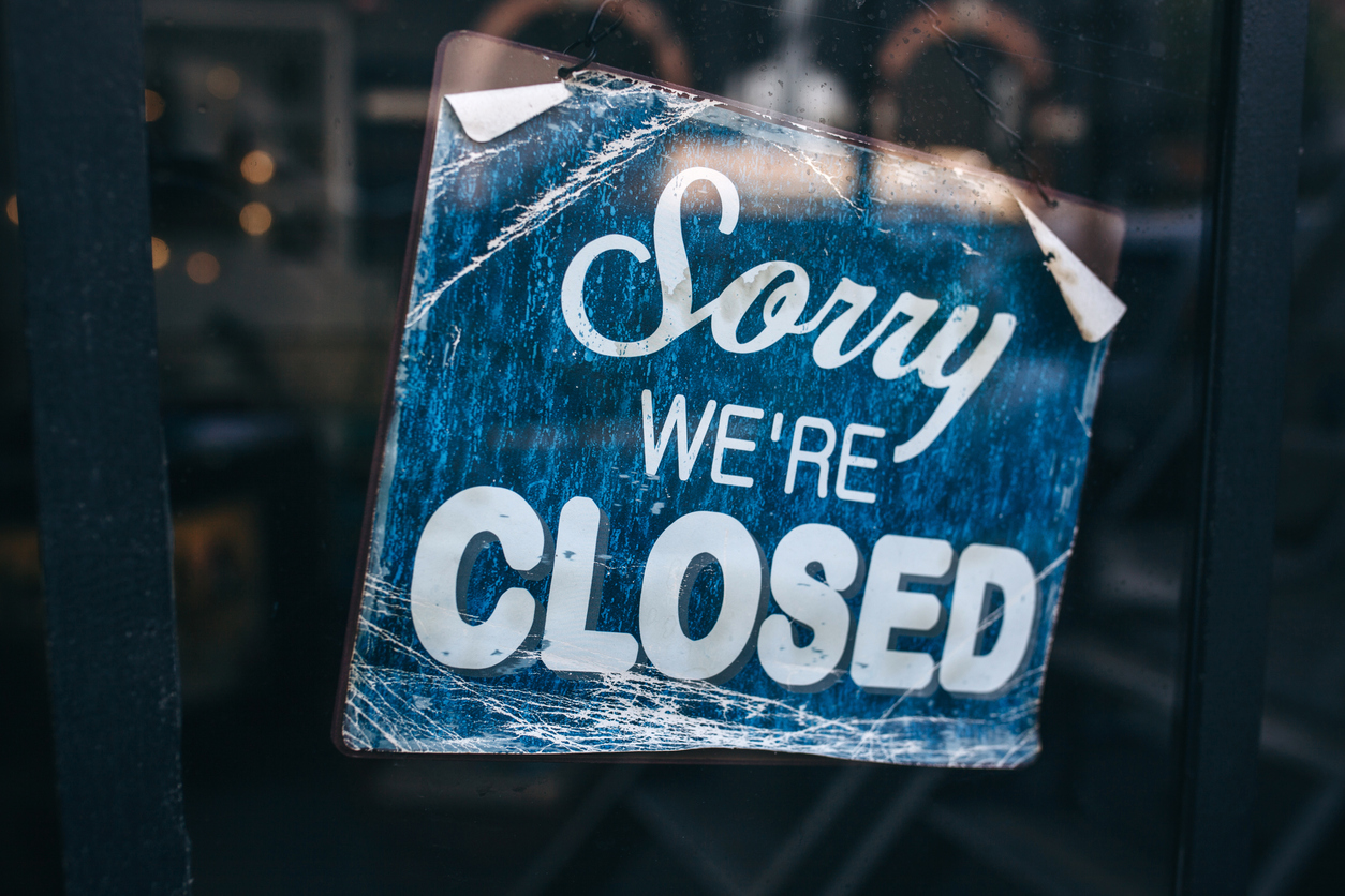 Sign on glass door that reads "Sorry We're Closed"