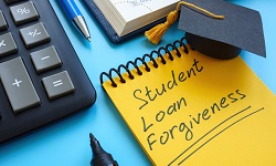 a notepad with the words Student Loan Forgiveness written on the front page