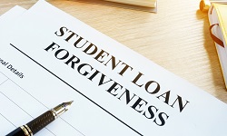 A pen and a piece of paper with student loan forgiveness written up top