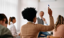 A student raises her hand in a classroom