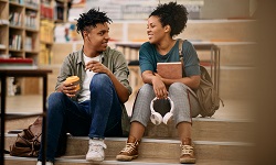 Two students chat in a library