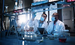 Two scientists wearing masks in a medical lab