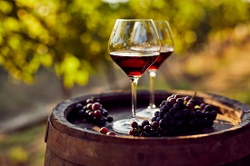 wine and grapes atop a barrel