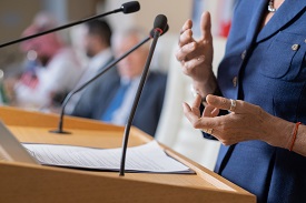 Woman addressing an audience from a podium