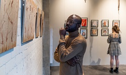 Visitors looking at paintings in a museum