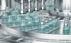 glass bottles with clear liquid on an automatic conveyor line