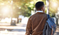 A picture of a man facing away with a backpack