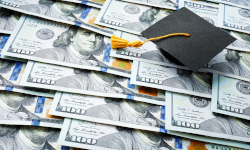 Sheets of $100 bills with a black graduation cap
