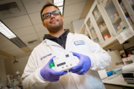 A scientists holding a device
