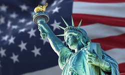 The Statue of Liberty against the backdrop of an American flag